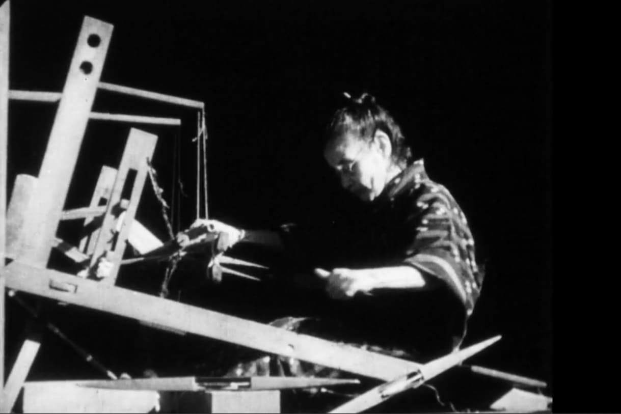 A female artisan operating a loom, skillfully handling threads to weave fabric