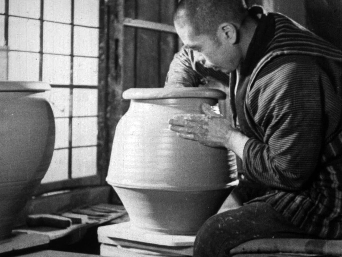 A potter shaping a large vessel on a wheel