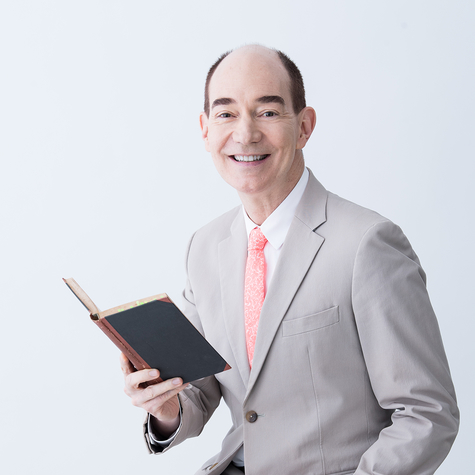A portrait of Robert Campbell, smiling and holding a book in his right hand