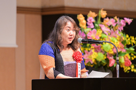 演題のマイクを前にスピーチをする塩田氏