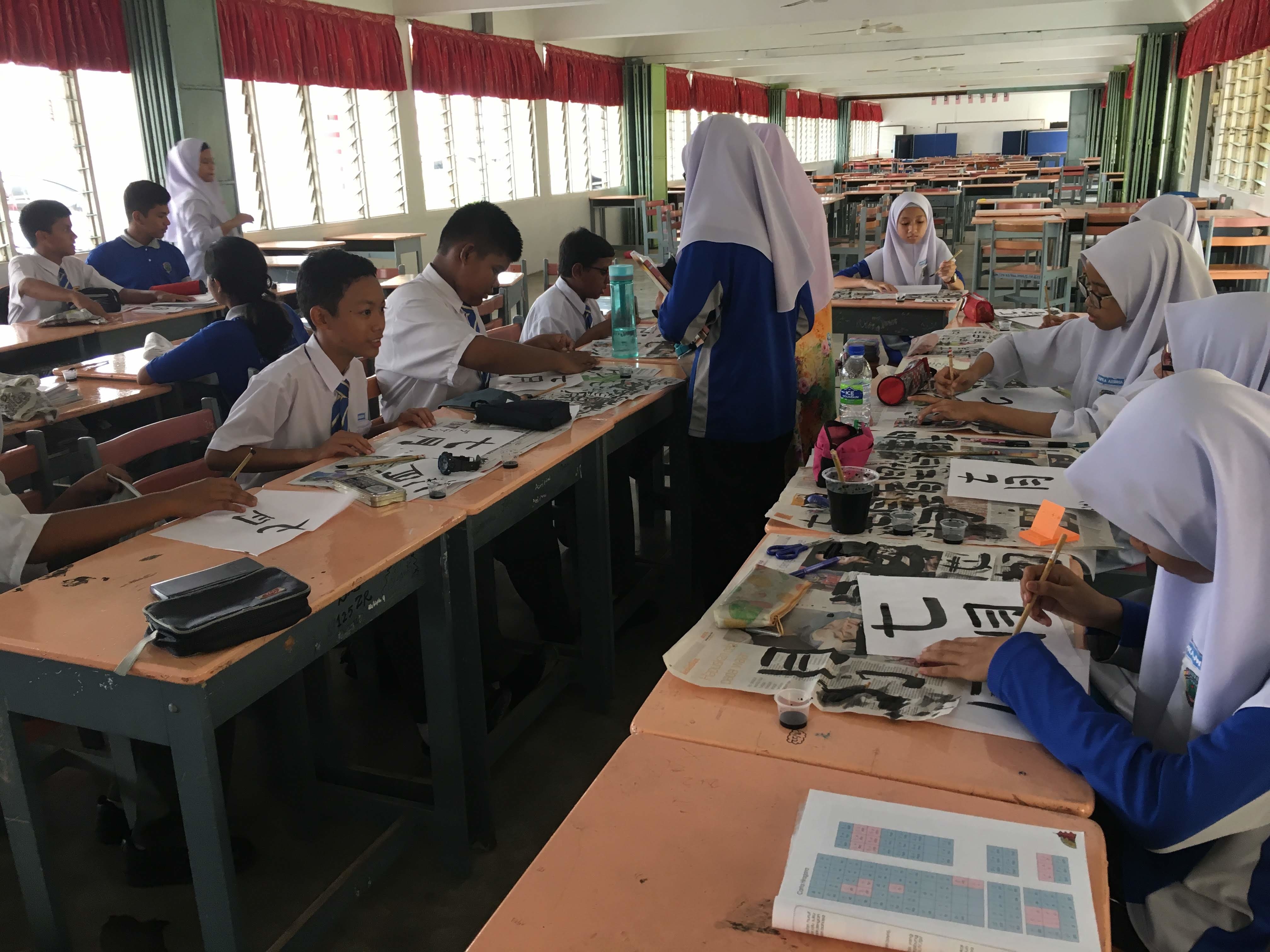 Secondary school students in Malaysia practicing calligraphy in a classroom